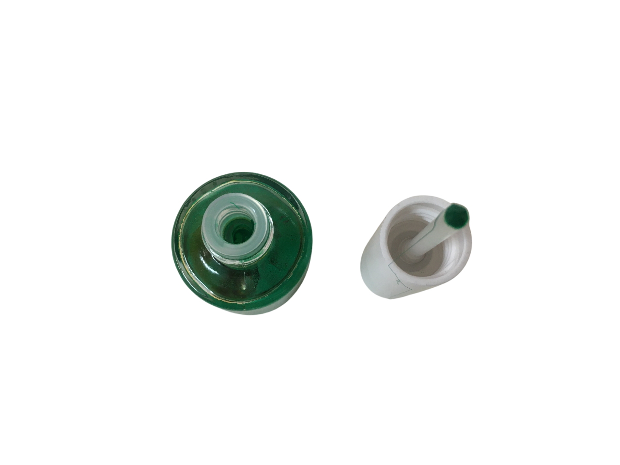 Vista dall'alto del flacone di smalto verde e tappo con tampone